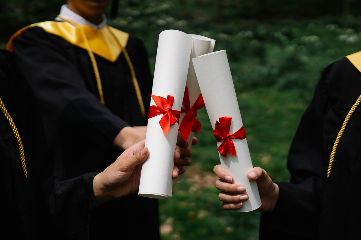 Photograph of People's Hands Holding White Diplomas